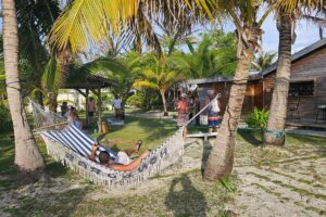 Guests enjoyig hammocks and corn hole game